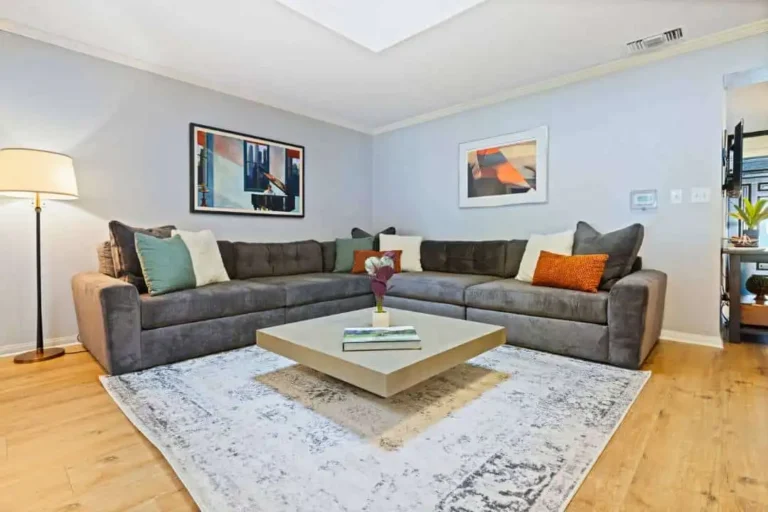 Living room with large sectional sofa and artwork on light blue walls