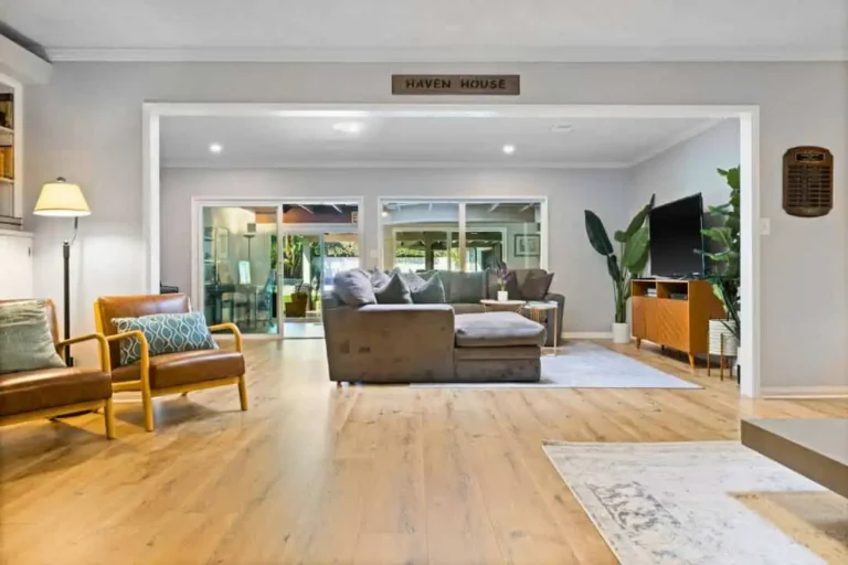 Open-plan living area with a Haven House sign above the doorway, sofa and TV