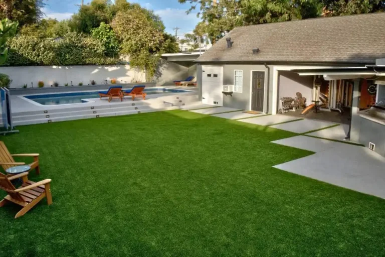 Backyard with a pool, lounge chairs and artificial turf lawn