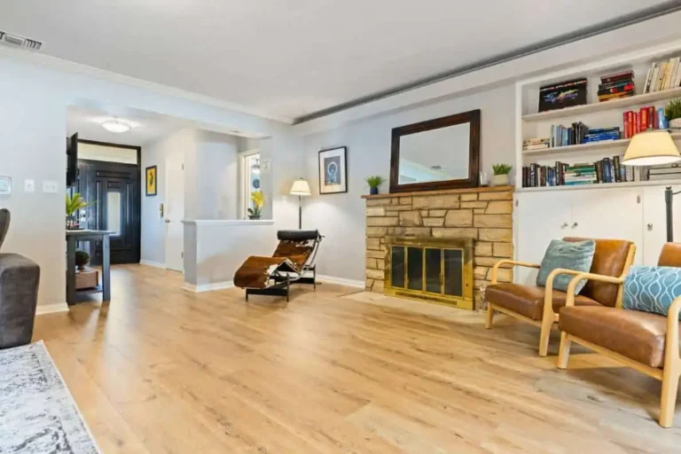 Interior living room with a stone fireplace, leather chairs and built-in bookcase