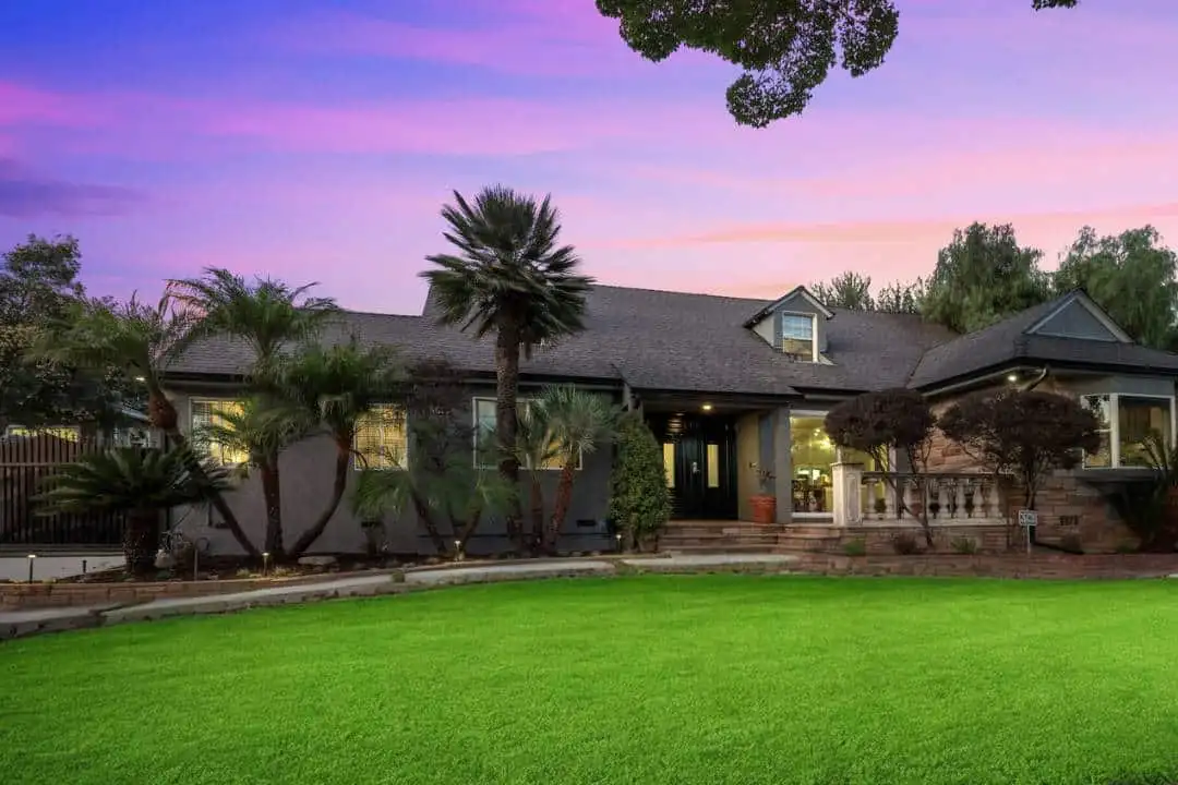 Haven House facility exterior at dusk with palm trees, green lawn and a purple-pink sky in Los Angeles