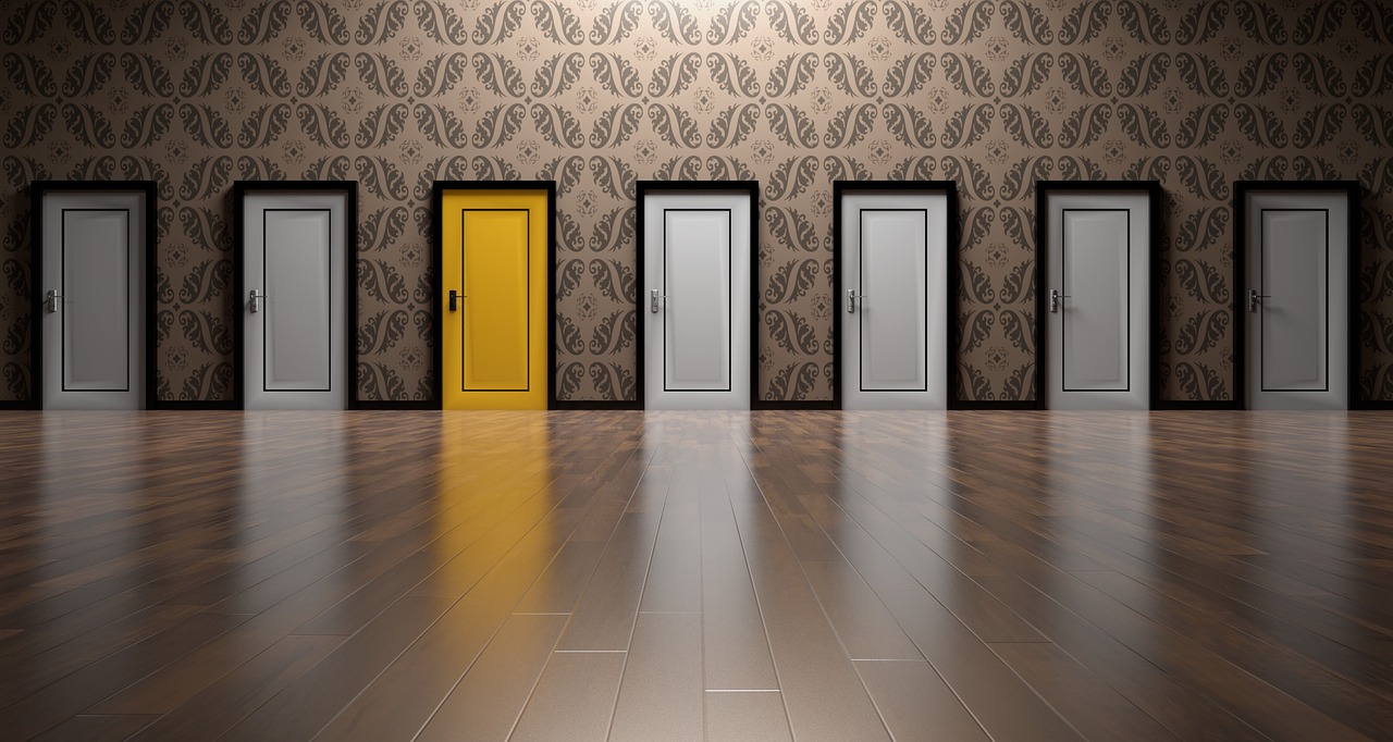 Row of identical white doors with one standout yellow door