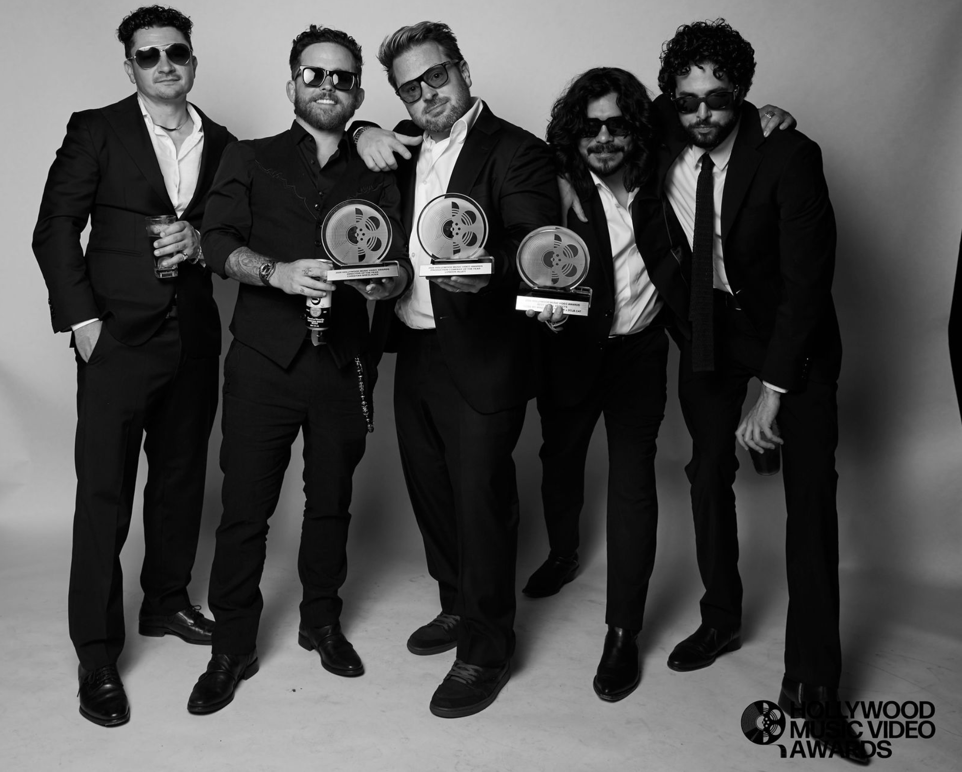 Five men in suits holding HMVA film reel trophies