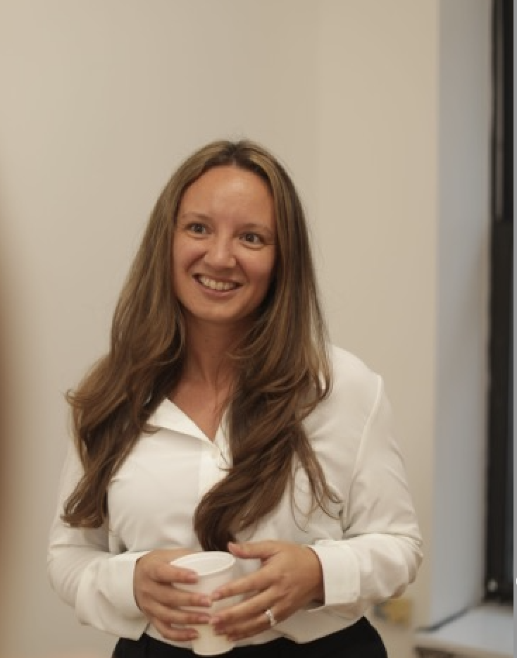 Stephanie Telibasa, PT, DPT — owner, in a white button-down holding a coffee cup
