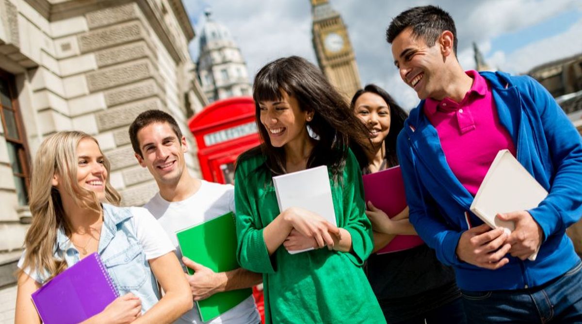 Group of five smiling students with notebooks in front of Big Ben