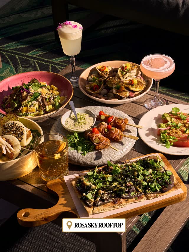 Overhead spread of dishes and cocktails at Rosa Sky Rooftop