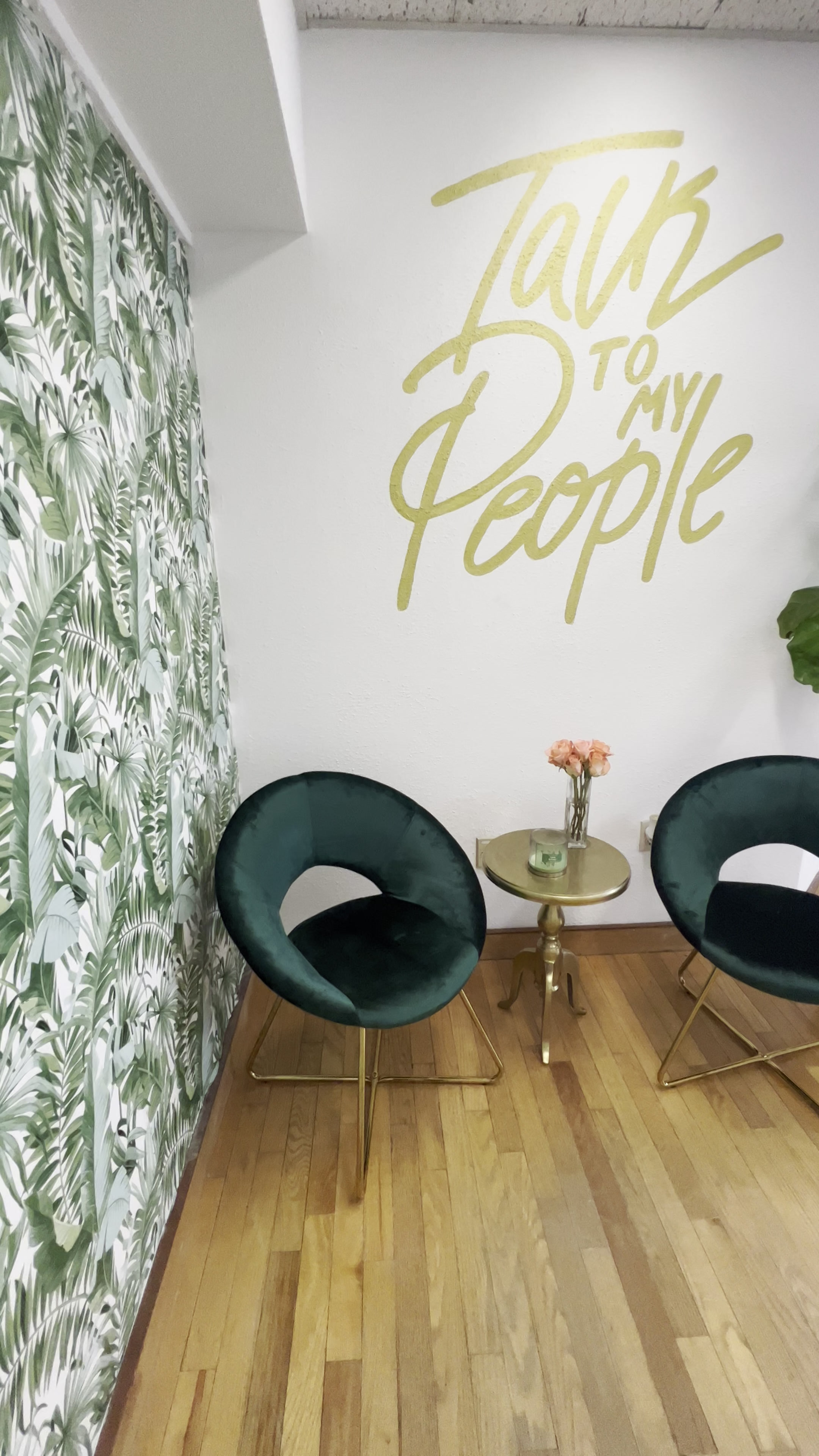 Identity Media PR office reception with tropical leaf wallpaper, green velvet chairs and a gold Talk to My People mural
