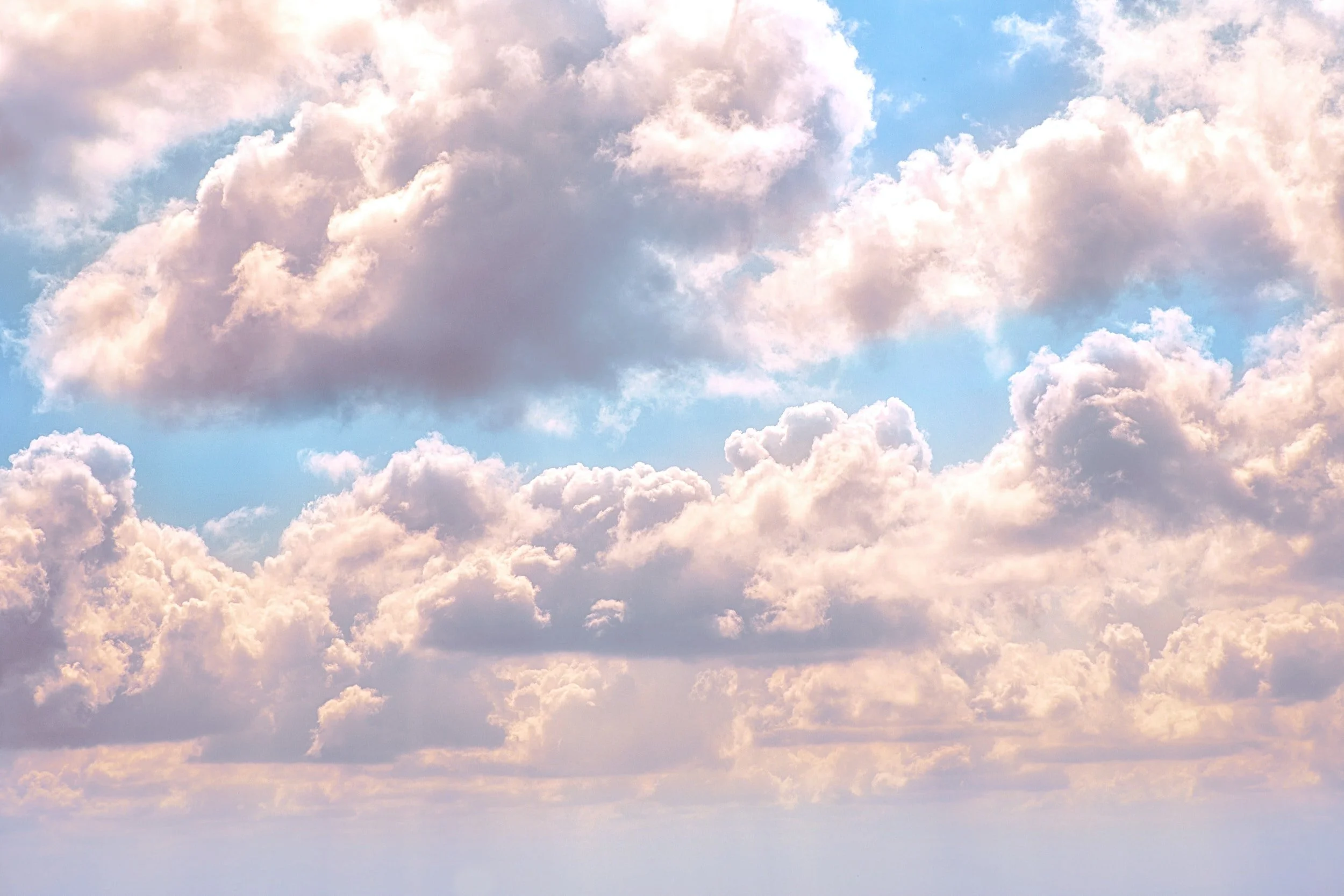 Fluffy pastel pink and blue cumulus clouds