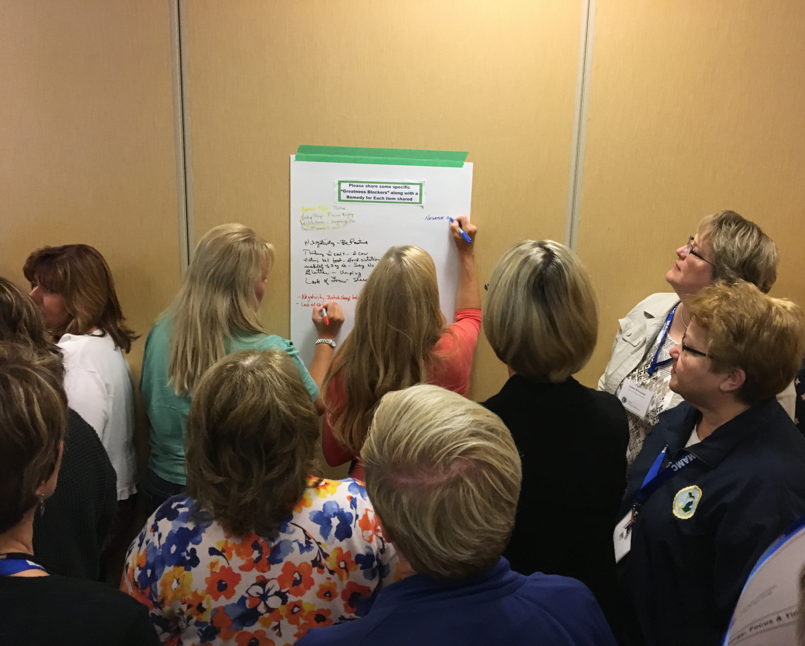 Women writing on a flip chart during a team-building workshop