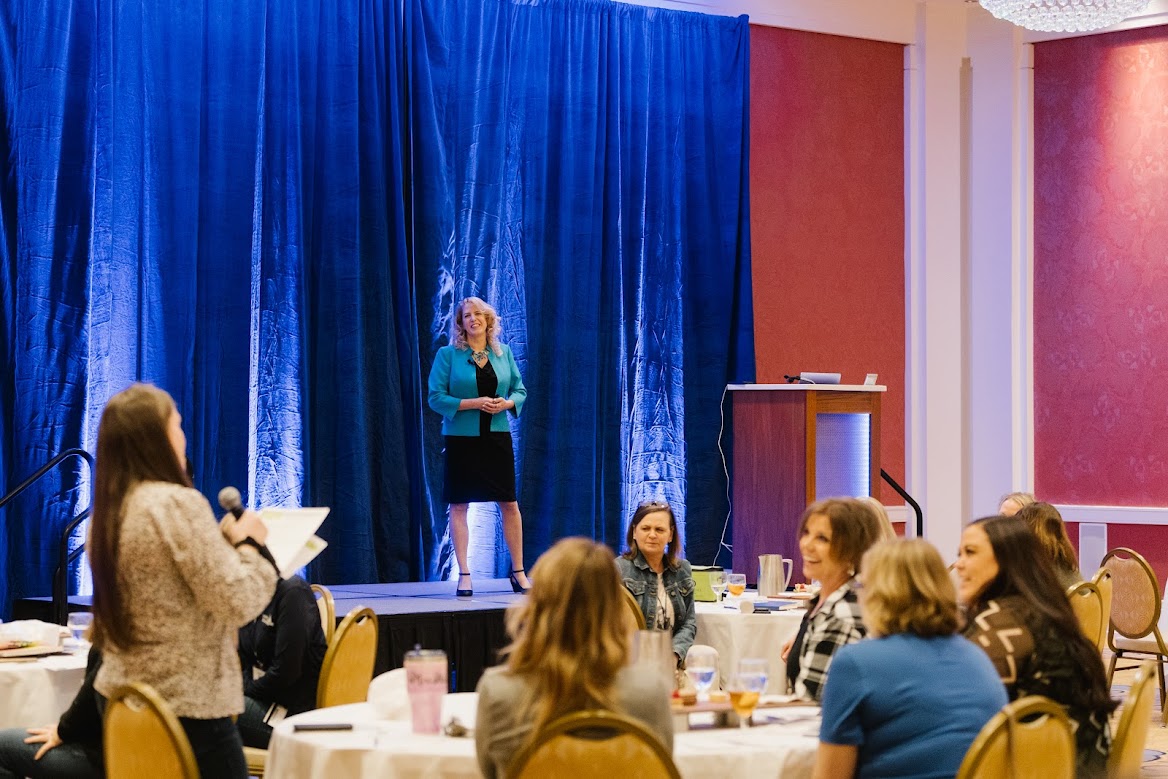 Michelle Steffes speaking on stage before a seated audience