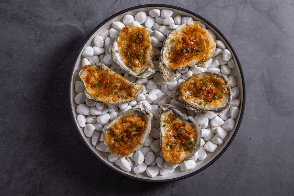 Lahsooni oysters served on a bed of white pebbles