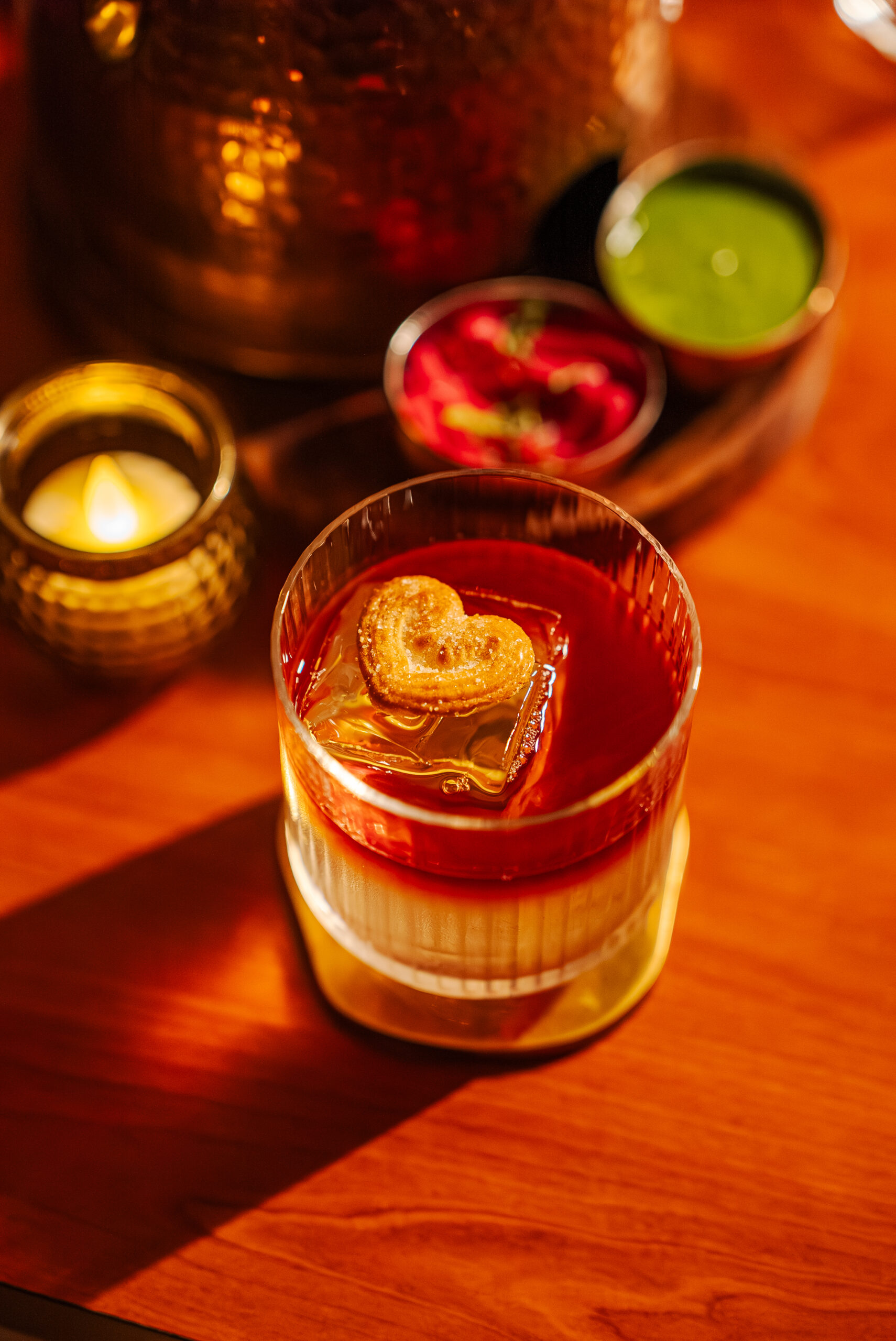 A candlelit table setting at Ishq with cocktails and small plates
