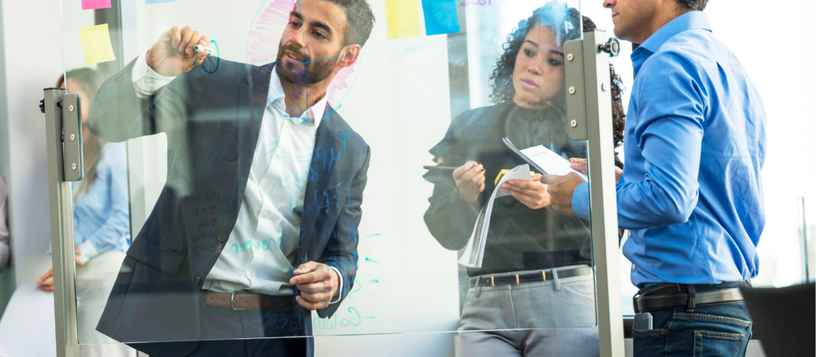 Team at a glass whiteboard with sticky notes