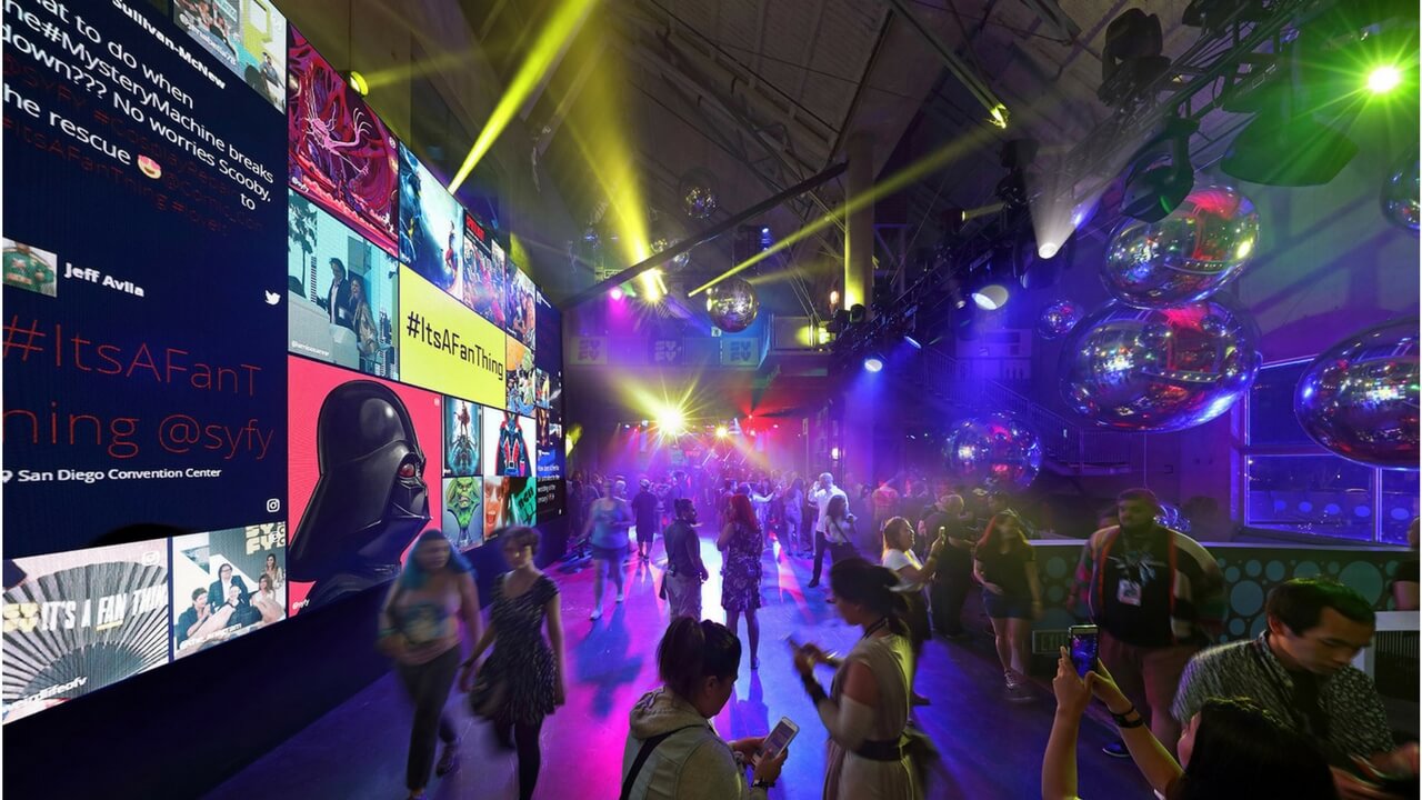 Indoor Syfy Comic-Con activation with large LED screens, disco balls, and crowd