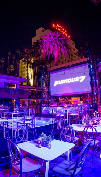 Furious 7 after-party at Hotel Roosevelt outdoor venue with screen displaying movie logo
