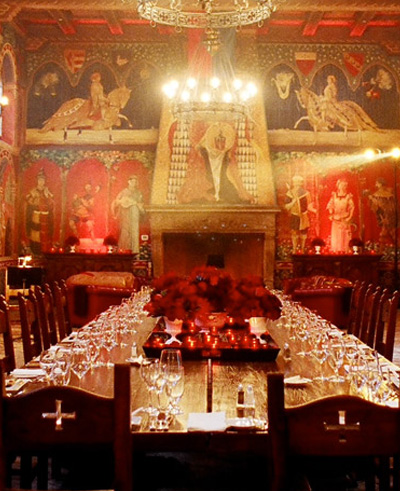 Ornate gothic banquet dining room with red murals and a chandelier