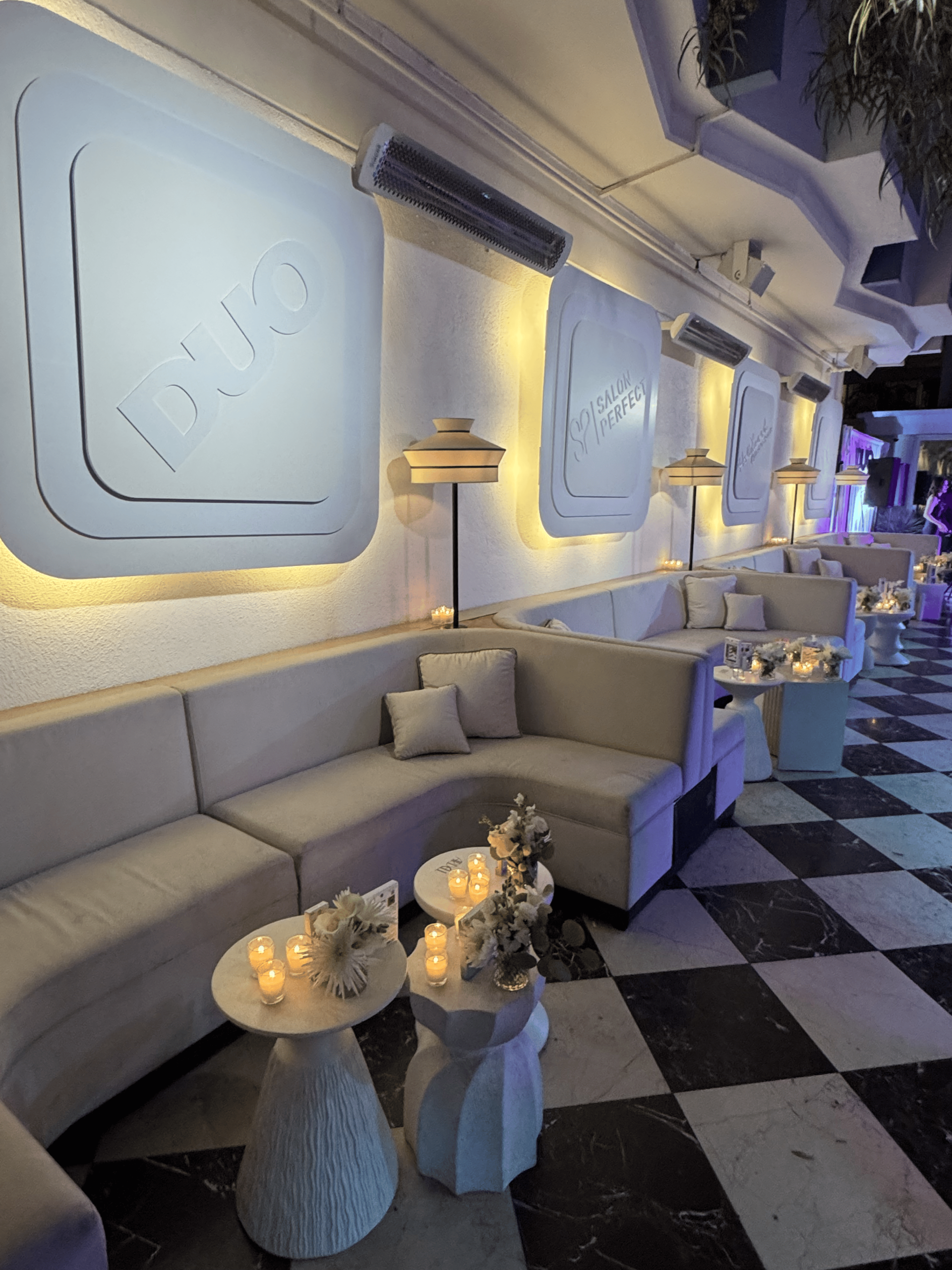Elegant lounge with white curved banquettes, marble floor and DUO Salon Perfect wall panels