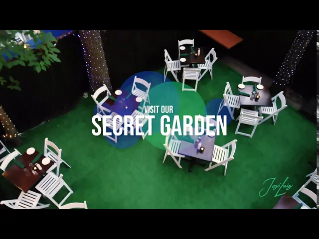 Overhead view of the José Luis Secret Garden patio with white chairs, tables and string lights
