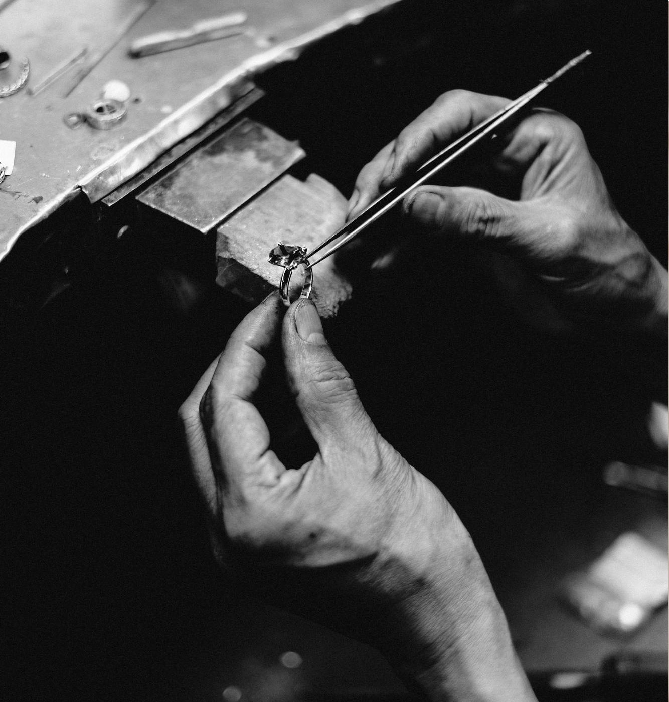 Kathe's jeweler setting a gemstone into a ring by hand at the workbench
