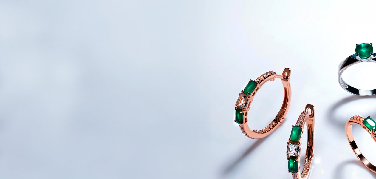 Rose gold and emerald hoop earrings with an emerald solitaire ring