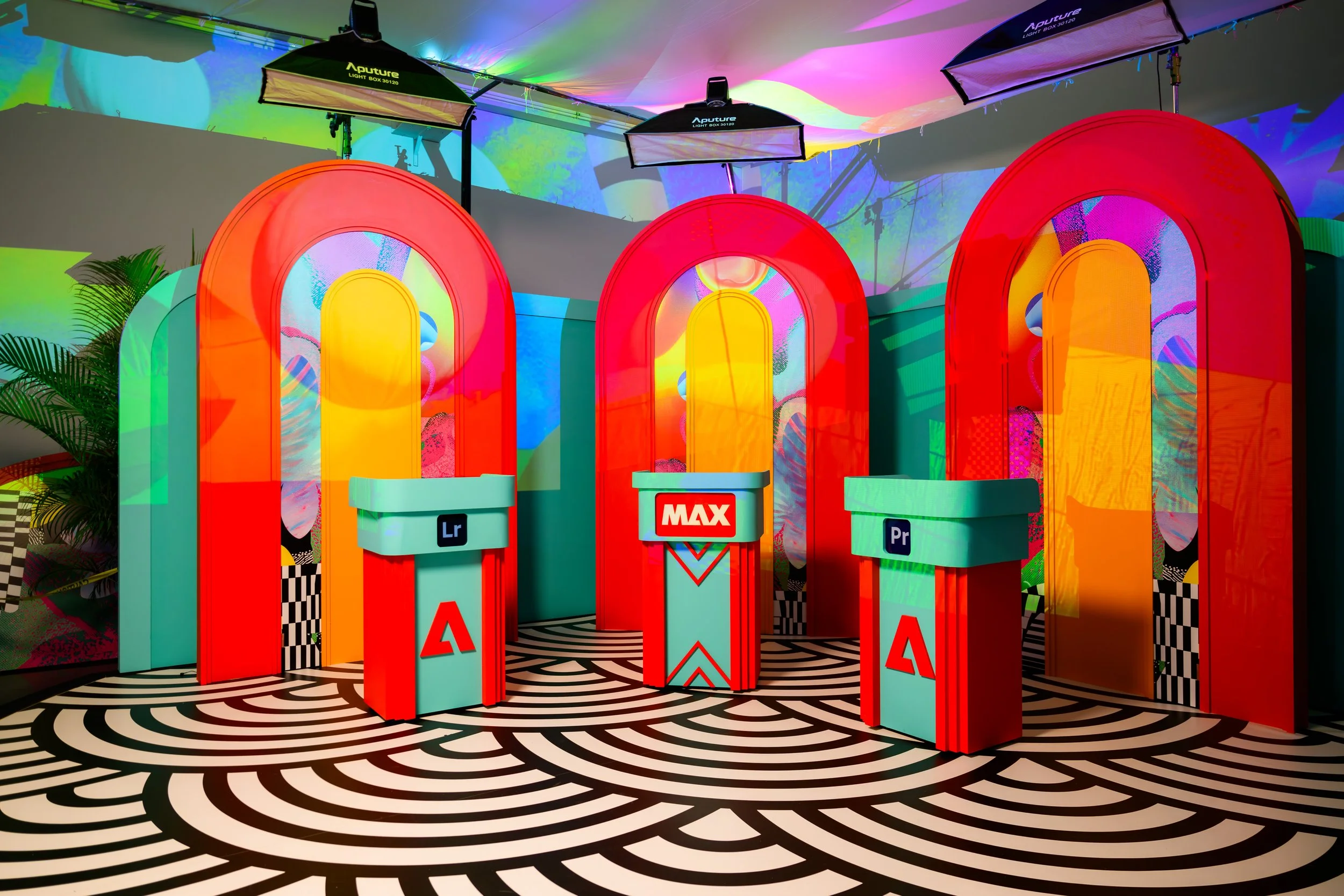 Three red arch installations branded Lightroom, MAX and Premiere Pro at Adobe MAX