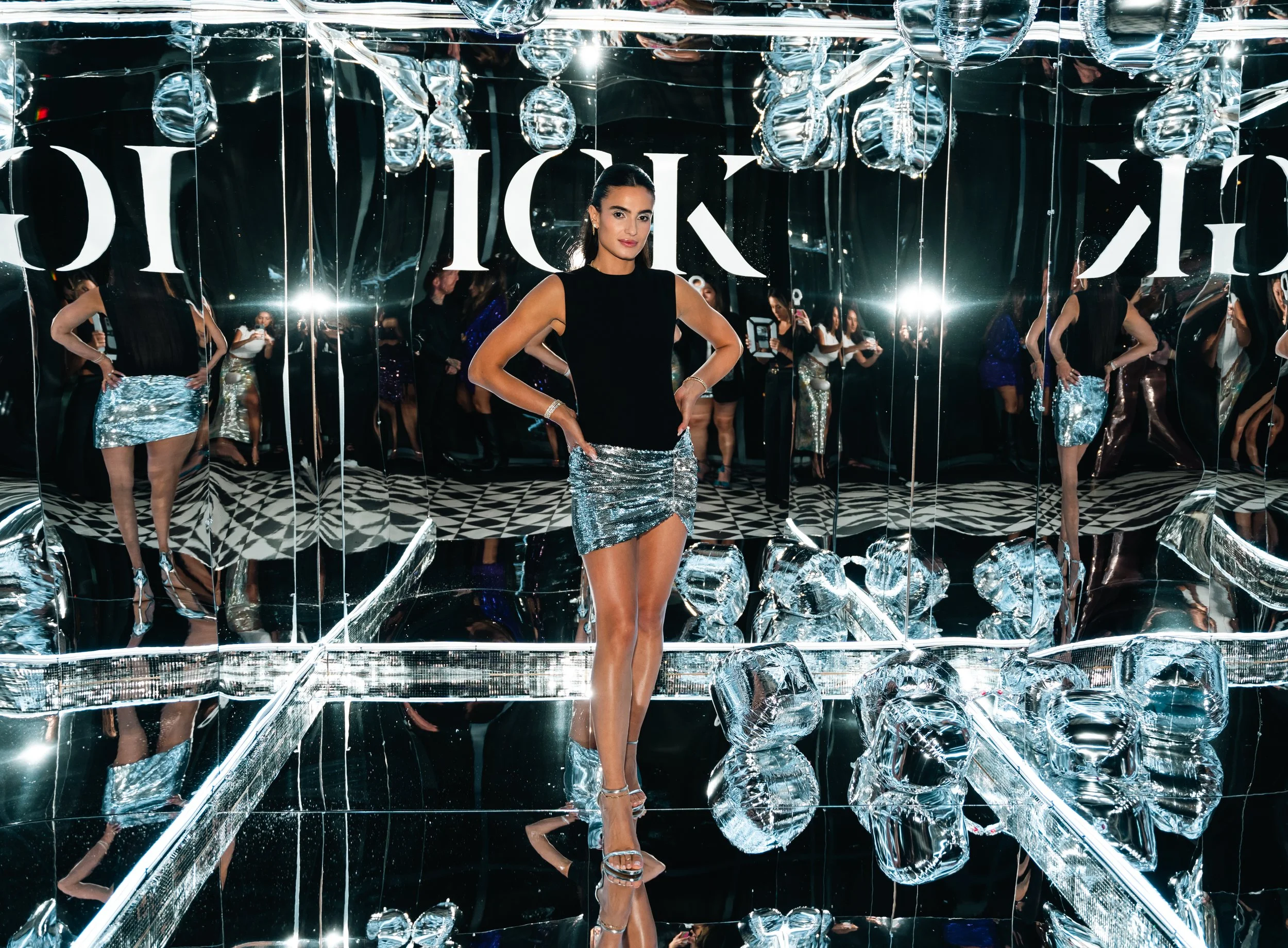 Woman in a sequin skirt inside a mirrored disco-ball room at the IGK event