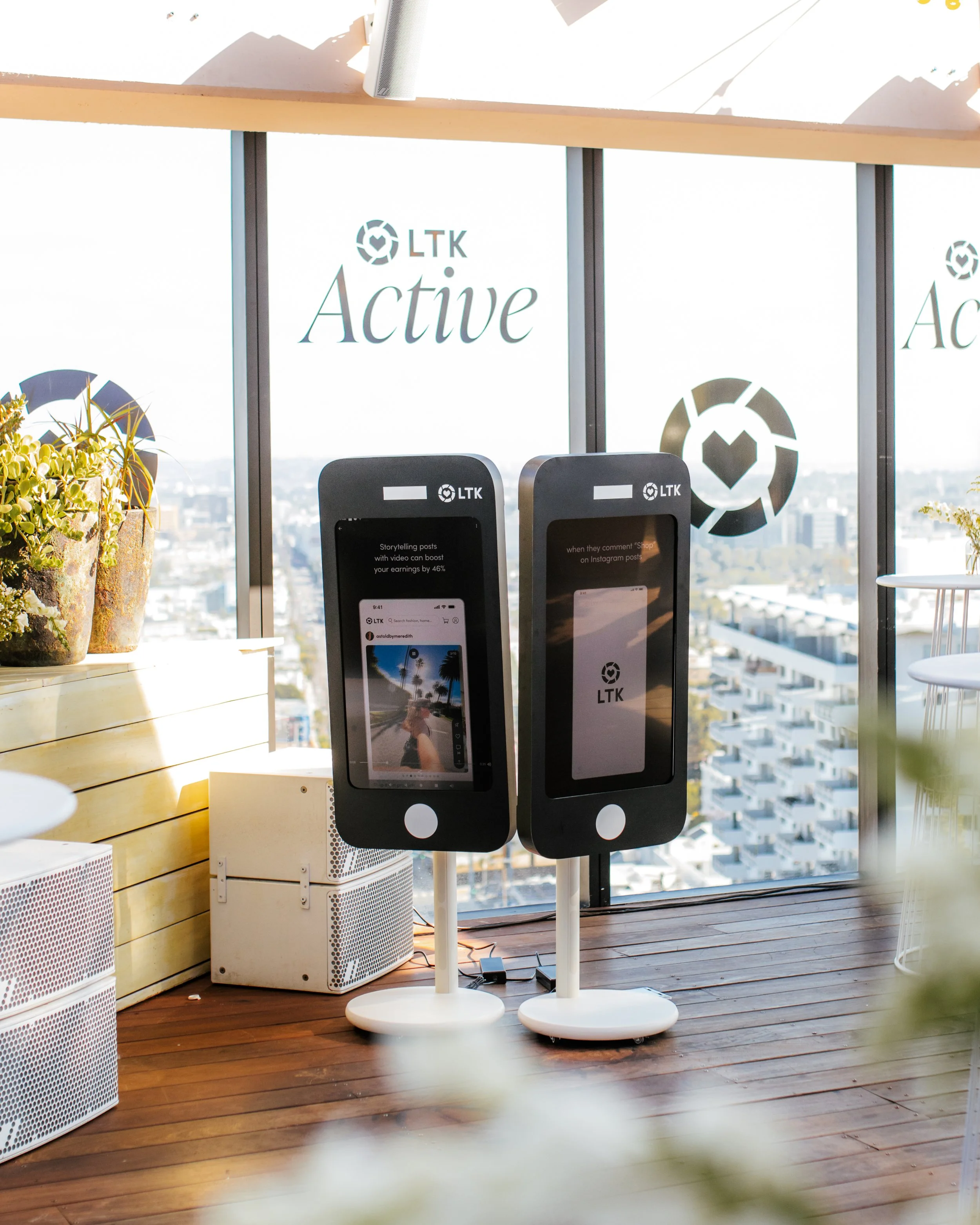 Two LTK-branded phone-shaped digital kiosks on a rooftop deck