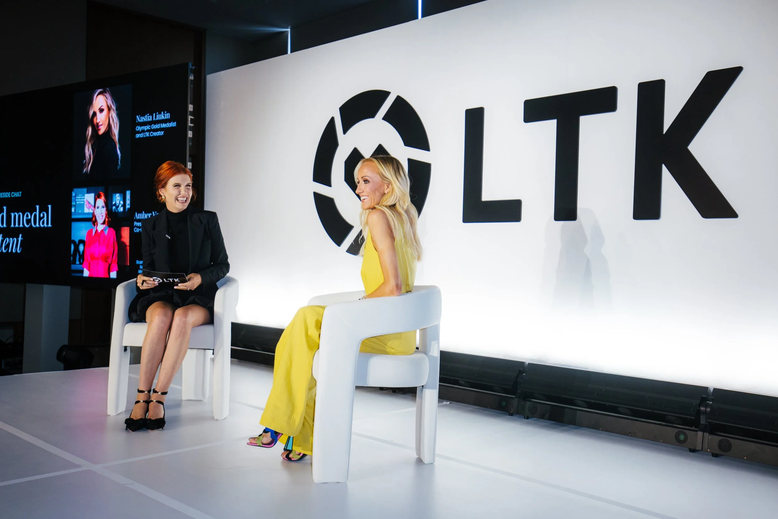 Two women on stage in front of a large LTK logo backdrop