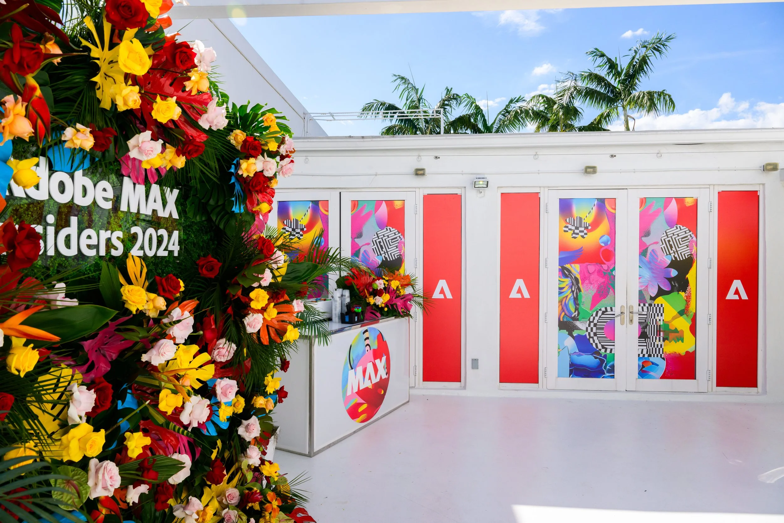 Adobe MAX Insiders 2024 entrance with tropical floral wall and branded doors