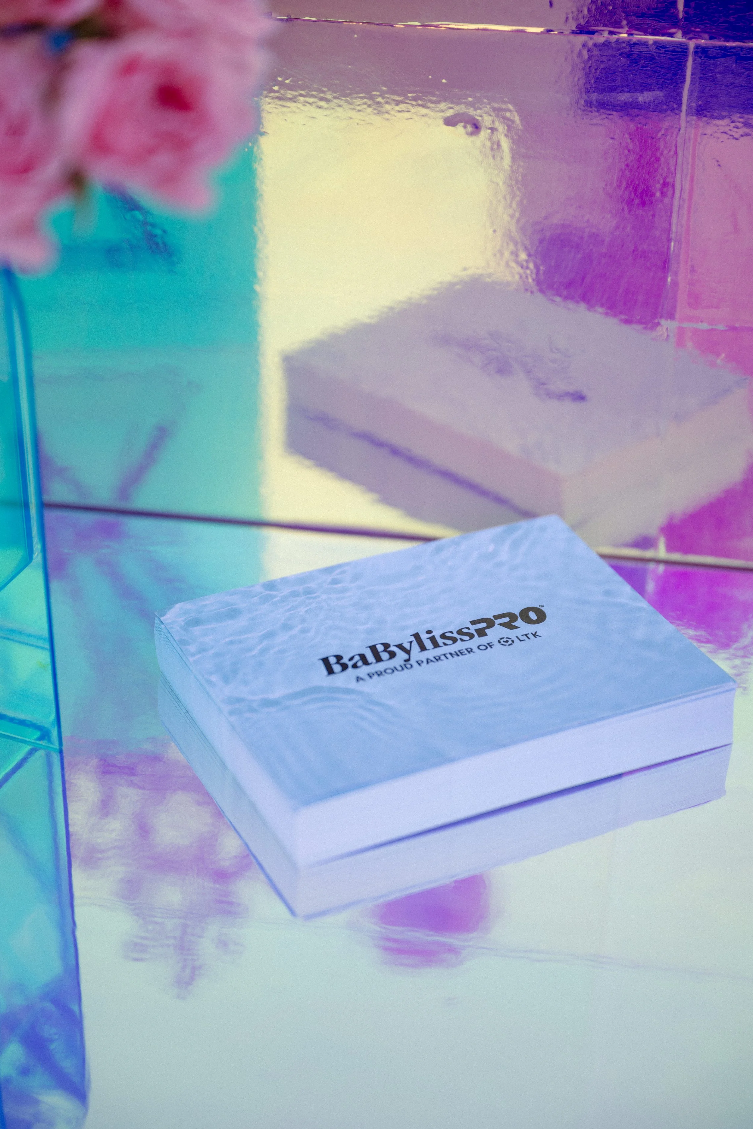 BaBylissPRO gift box on an iridescent surface with pink roses