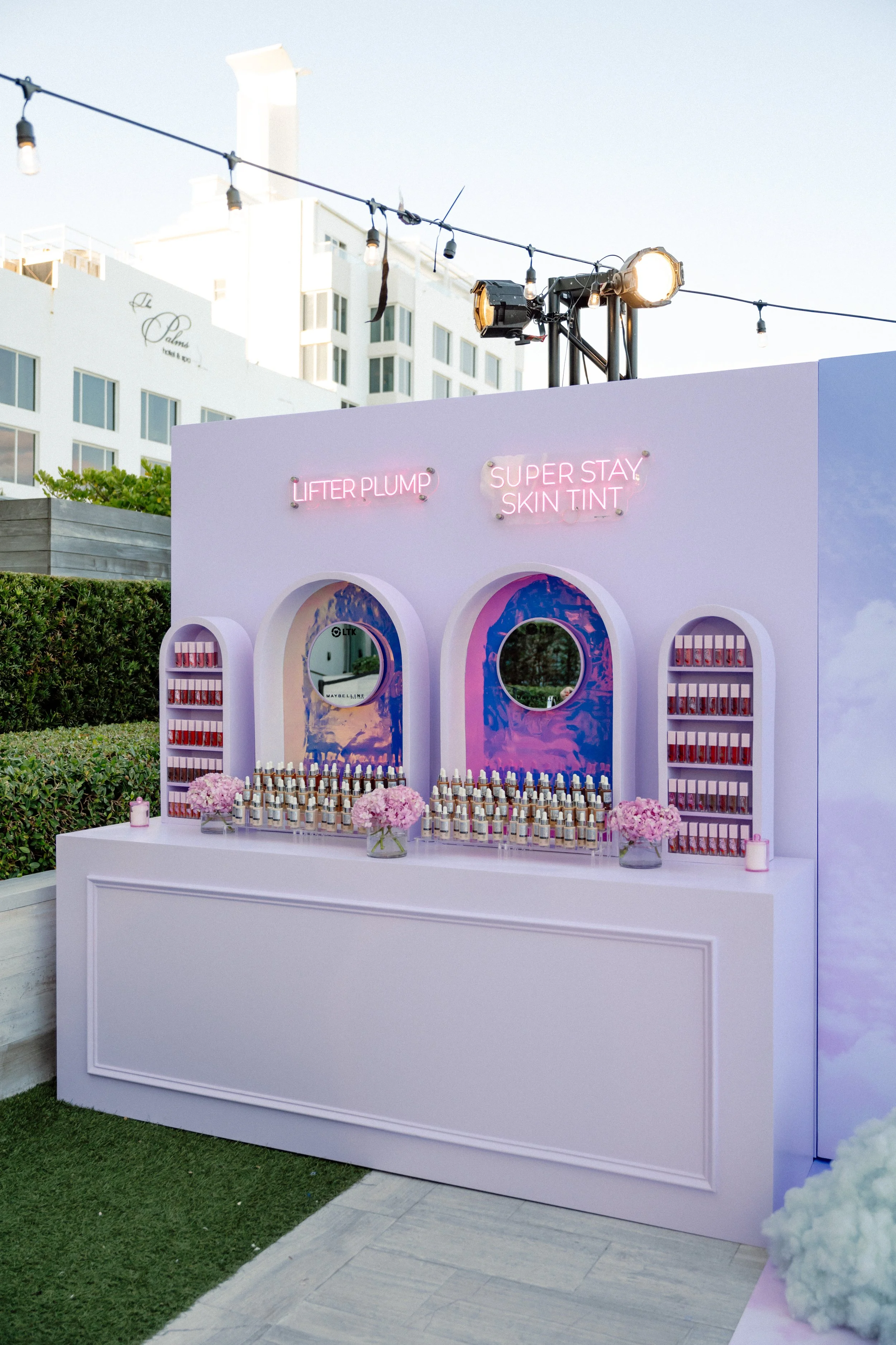 Maybelline outdoor product display with lavender arches and neon Lifter Plump signage