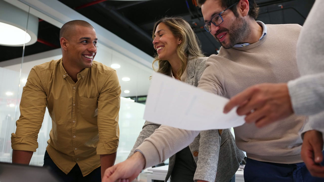 Three professionals collaborating over a document in a modern office