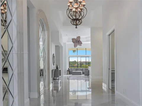 Grand foyer with arched mirrors and chandelier at 7426 Nw 2nd Avenue, Miami