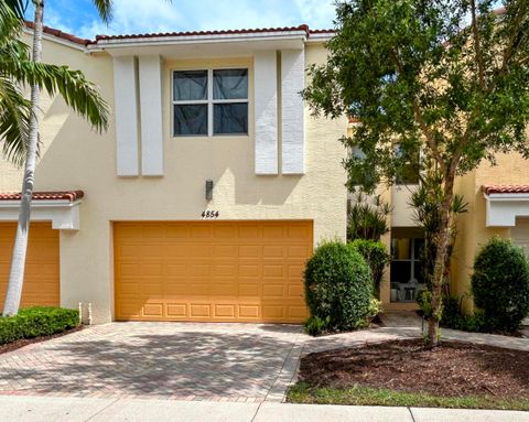 Two-story Mediterranean-style townhouse with orange garage door and palm tree at 3803 Nw 5th Terrace, Boca Raton