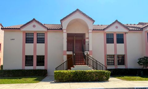 Two-story pink stucco condominium building with arched entrance at 9165 Sw 14th Street, Boca Raton