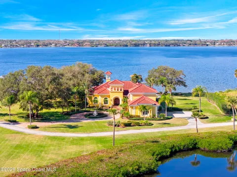 Aerial view of a waterfront luxury estate with red tile roof at 135 Chilean Ave, Palm Beach