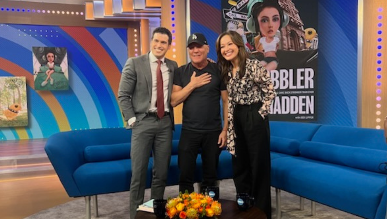 Three people on the Good Morning America set beside a book display for “Cobbler” by Steven Madden