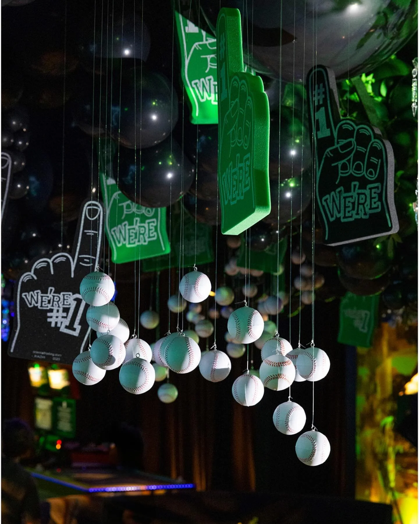 We're #1 — hanging baseballs and foam fingers under green lighting