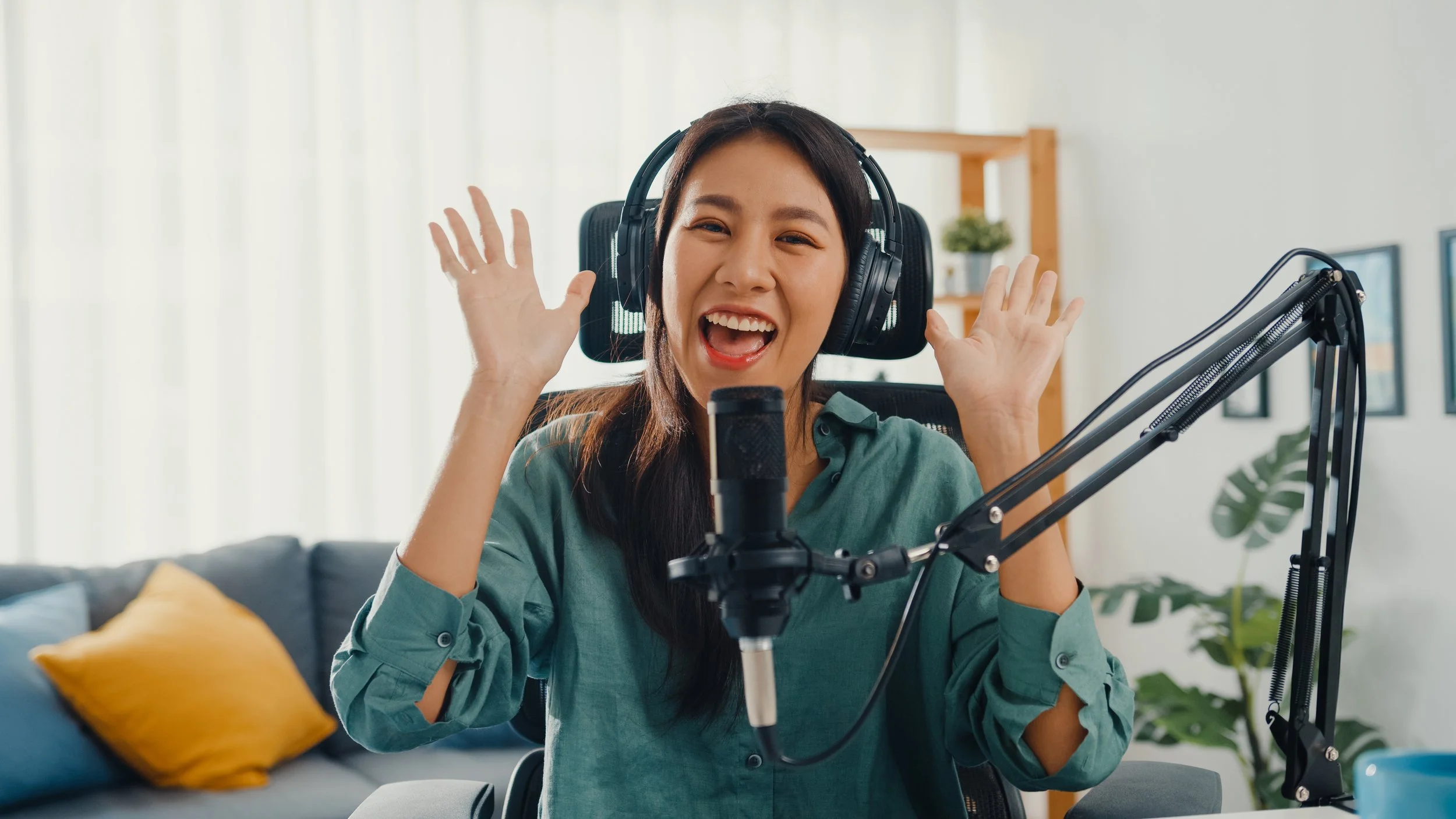 Woman with headphones laughing into a microphone