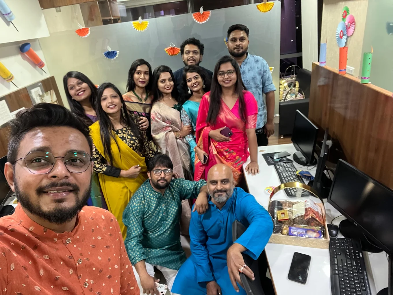 Large group of team members in Indian festive attire celebrating Diwali in the office