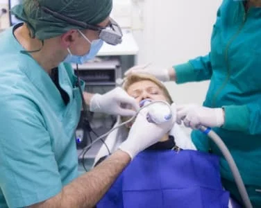 Dental surgeon and assistant performing a procedure on a patient