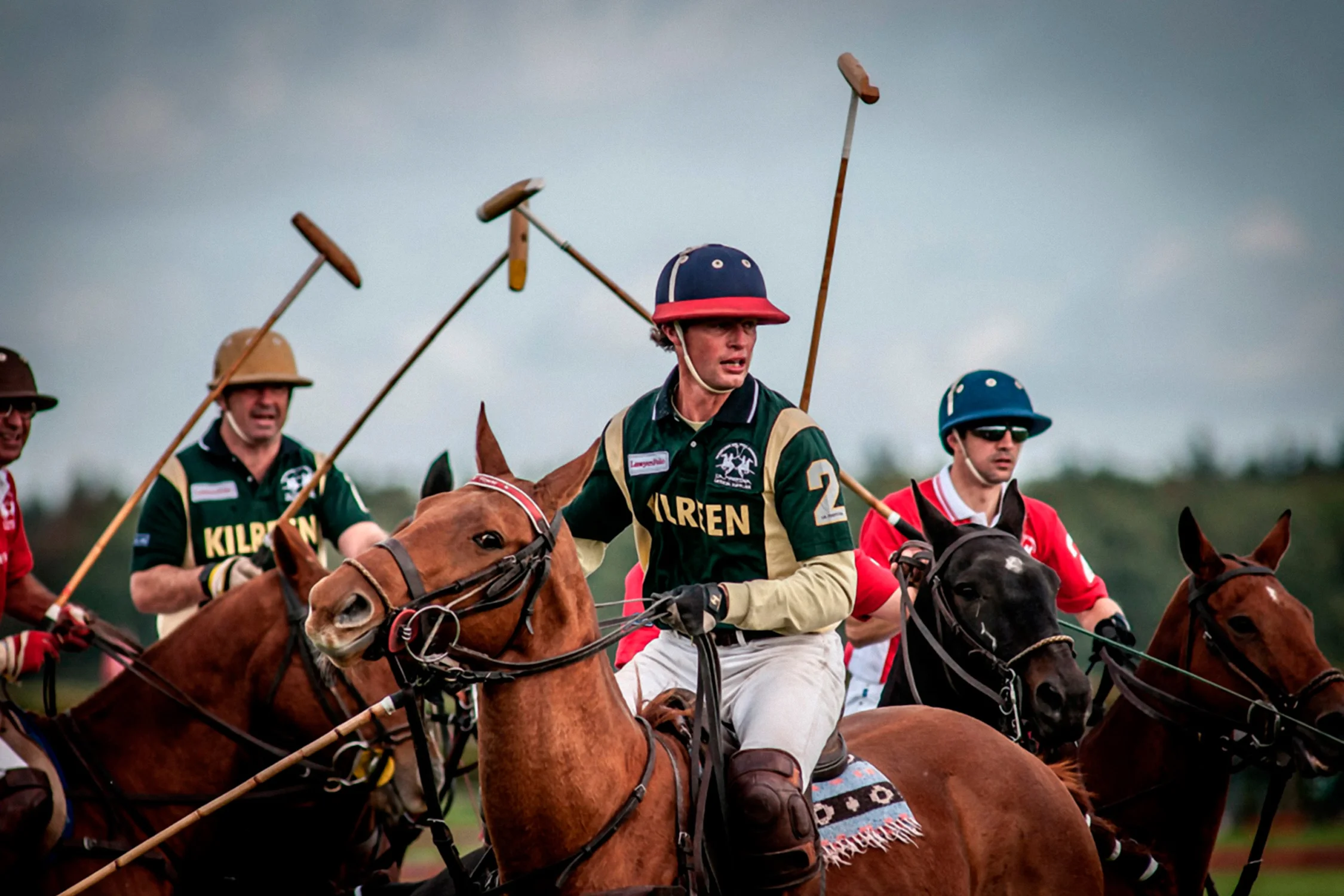 Close-up polo action, Kilren jerseys, mallets raised mid-match
