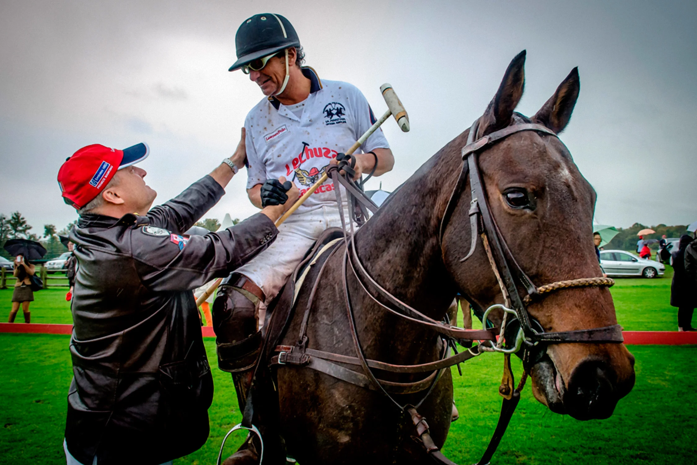 Rider and groom after the match, muddy on the grass