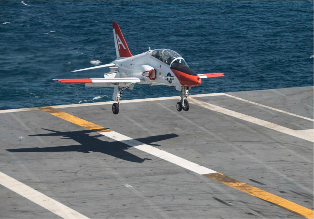 T-45 Goshawk jet trainer landing on an aircraft carrier deck at sea