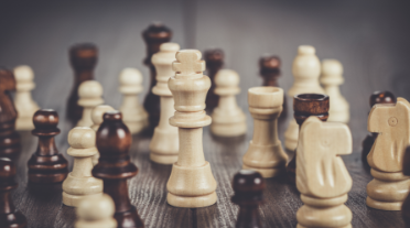 Wooden chess pieces arranged on a chessboard