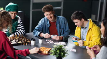 A diverse group of young people playing board games at a table