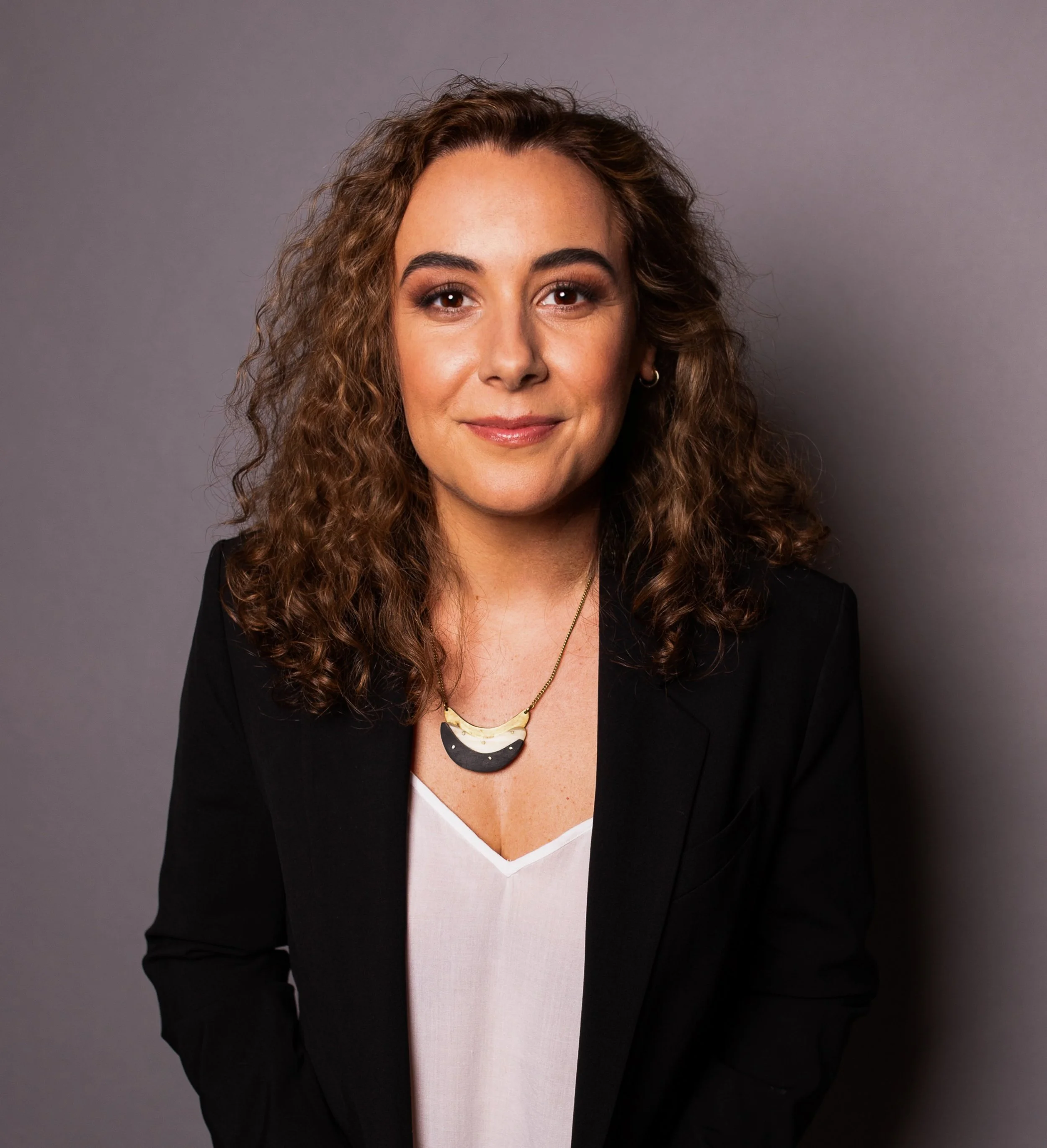 Nicole Bliss, professional headshot in a black blazer and white top