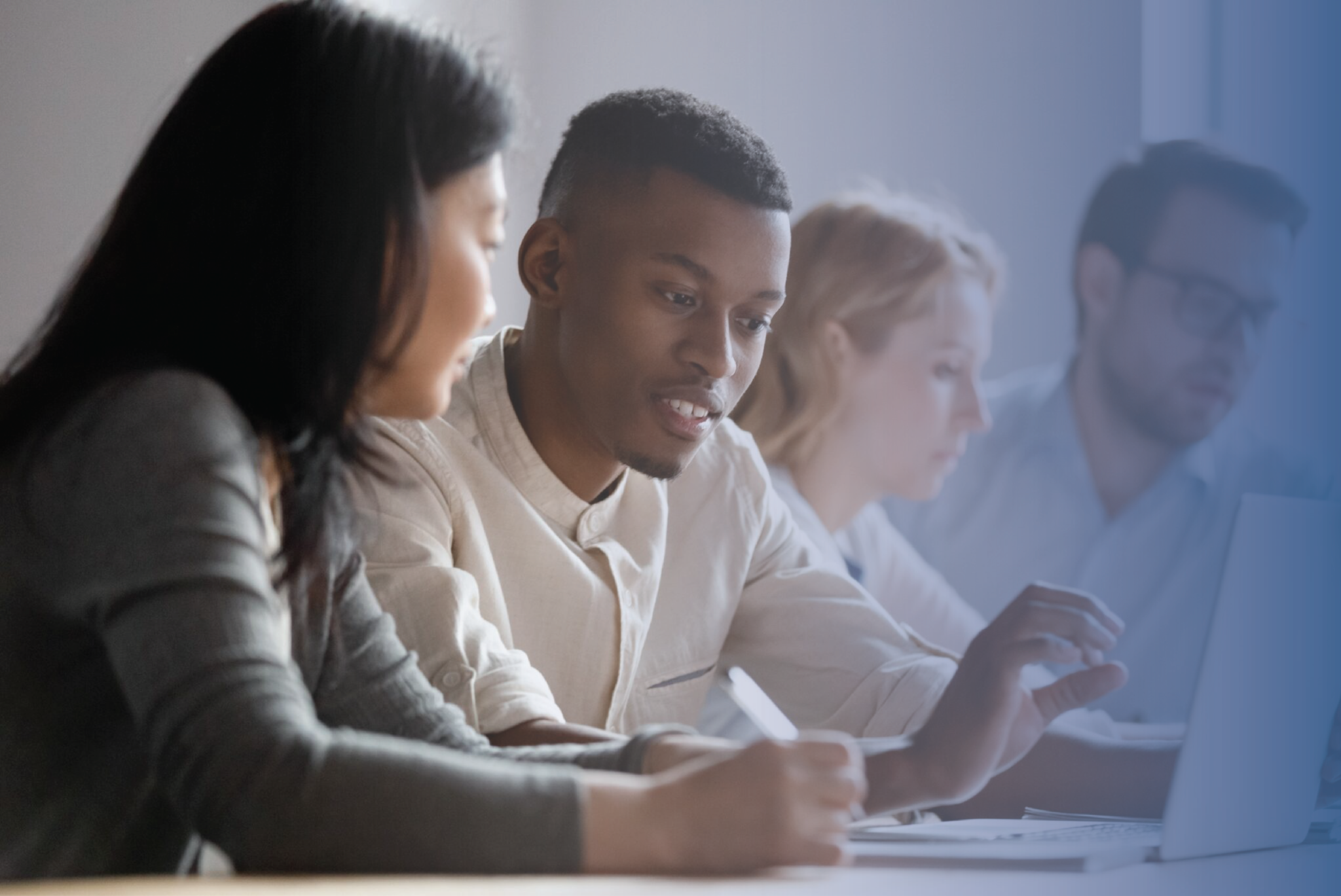 Young professionals studying together at a table with laptops