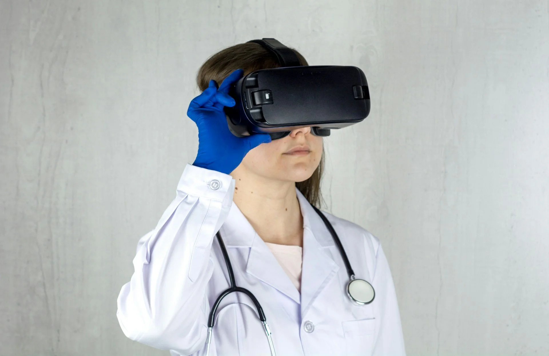 Doctor wearing a VR headset with blue surgical gloves
