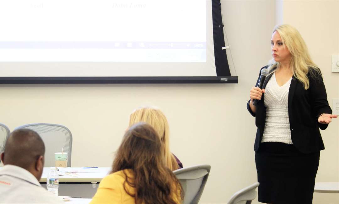 Tracy Minnec presenting at a microphone during a leadership workshop